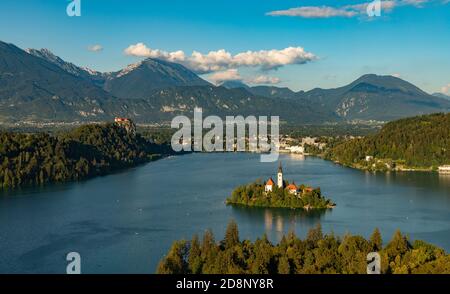 Ein Bild des Bleder Sees und der umliegenden Landschaft, mit der Insel Bled in der Mitte, aus einem Aussichtspunkt gesehen. Stockfoto