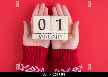 Erster Tag des glücklichen neuen Jahres Konzept. Oben über der Decke Nahaufnahme Foto von weiblichen Händen halten Kalander mit dem ersten Januar isoliert über b Stockfoto