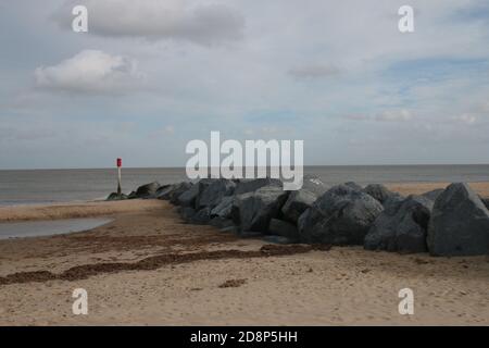 Wunderschöne Landschaft über sandigen einsamen Strand in Richtung Ozean Horizont weit Sand stretch & Holz groyne Barriere aus dem Meer niedrig Gezeiten Herbstspaziergang Norfolk Stockfoto