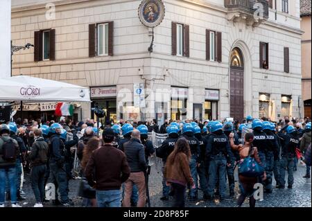 Demonstranten, die italienische Flaggen schwenken, stoßen während der Demonstration auf die Bereitschaftspolizei.Protest gegen die restriktionellen Maßnahmen der Regierung zur Eindämmung der Ausbreitung von COVID-19-Infektionen in Rom. Stockfoto