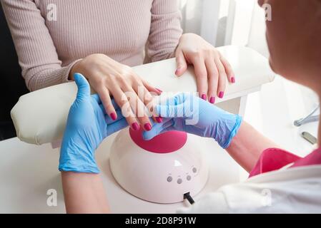 Oung Frau tut Maniküre im Salon. Schönheitskonzept. Stockfoto