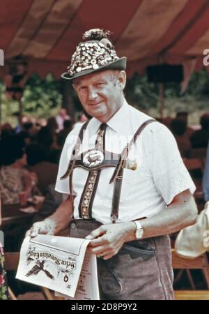 Besucher des fünften jährlichen Oktoberfestes in Helen; hält mit einer Kopie des Helen Mountain Eagle inne. Das monatliche Nachrichtenmagazin wurde im juli 1975 gegründet und bietet Artikel, die sowohl für Anwohner als auch für Touristen, die die Alpengemeinde besuchen, von Interesse sind. Das Dorf von 270 erlangte Anerkennung, als Geschäftsleute, Beamte und Bewohner die Renovierung des Geschäftsviertels mit einem bayerischen alpinen Thema befürworteten. Das Projekt ist ein Erfolg und hat zu zusätzlicher Entwicklung und mehr Tourismus geführt. Stockfoto