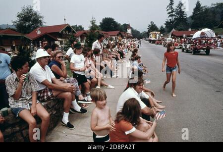 Touristen und Stadtbewohner säumen die Hauptstraße von Helen Georgia; in der Nähe von Robertstown für die Parade zum 4. Juli. Helen war eine typische kleine Berggemeinde von weniger als 300 bis Anfang 1969, als Stadtbeamte; Geschäftsleute und Bewohner befürworteten die Renovierung des Geschäftsviertels mit einem bayerischen alpinen Thema das Projekt war ein Erfolg und führte zu neuen Geschäften und einem Anstieg des Tourismus. In einem Planungsbericht wird darauf hingewiesen, dass ein Gleichgewicht zwischen Wachstum und öffentlichem Interesse erforderlich ist Stockfoto