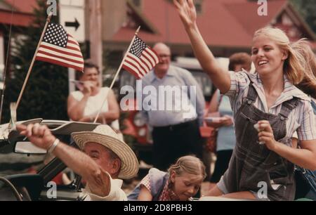 White County Beauty Queen (Overalls) und ihr Fahrer werfen Kaugummi und Süßigkeiten an die Menge entlang der Hauptstraße von Helen Georgia; in der Nähe von Robertstown während einer Parade am 4. Juli. Helen war ein typisches kleines Bergdorf mit weniger als 300 Einwohnern bis Anfang 1969, als Stadtbeamte, Geschäftsleute und Bewohner die Renovierung des Geschäftsviertels mit einem bayerischen alpinen Thema befürworteten.das Projekt war ein Erfolg und zog neue Geschäfte und einen Anstieg der Touristen an Stockfoto