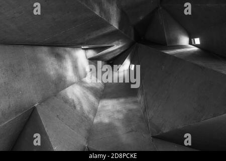 Schwarz-Weiß-Ton und Stimmung, Detail der rauen rohen Betondecke mit abstrakten geometrischen Mustern mit Licht und Schatten der brutalistischen Architektur. Stockfoto