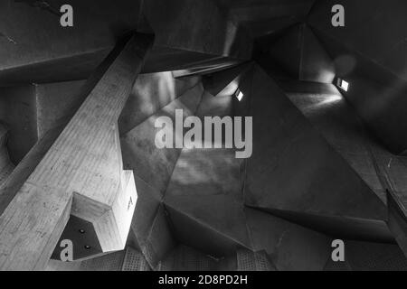 Schwarz-Weiß-Ton und Stimmung, Detail der rauen rohen Betondecke mit abstrakten geometrischen Mustern mit Licht und Schatten der brutalistischen Architektur. Stockfoto