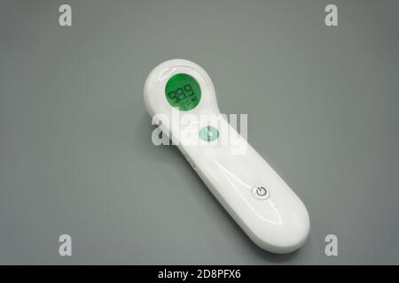 Medizinisches Stirn-Digitalthermometer auf grauem Hintergrund Stockfoto