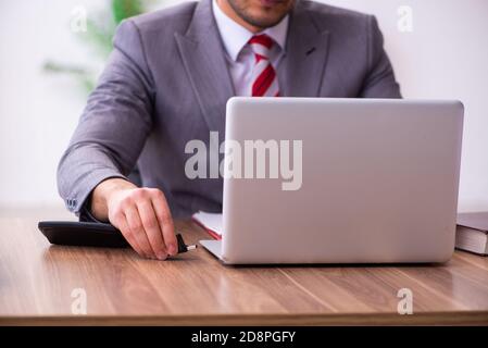 Männlicher Mitarbeiter, der Flash-Laufwerk in den Laptop einsteckt Stockfoto