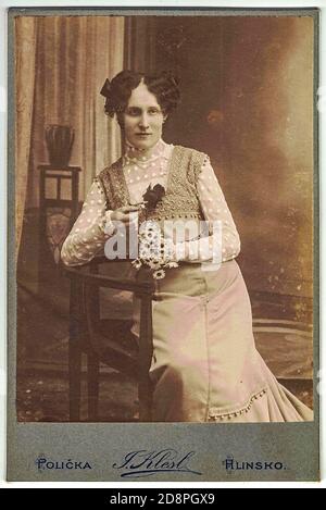 Vintage Kabinettkarte zeigt Frau posiert in einem Foto-Grafik-Studio. Das Foto wurde in Österreich-Ungarn oder auch in Österreich-Ungarn Monarchie aufgenommen Stockfoto