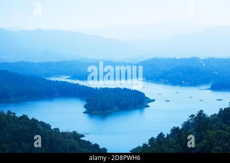Luftaufnahme eines blauen Sees im Morgennebel, Hausboot Gemeinschaft im See. Nan, Thailand. Stockfoto