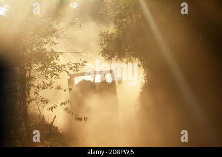 Rückansicht des militärischen Jeeps auf einer staubigen Straße in einem Wald. Stockfoto