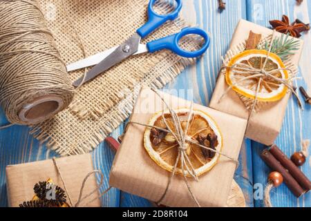 Accessoires, Dekoration, Holzschlitten und verpackte Geschenke für Weihnachten oder andere feiern auf Brettern liegend Stockfoto