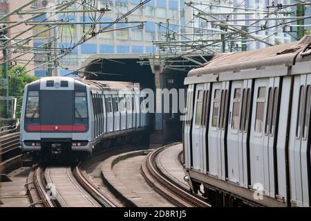 Züge fahren in der Nähe eines akustischen Gehäuses auf der Tsuen Wan Line des MTR-Systems von Hongkong, 2020 Stockfoto
