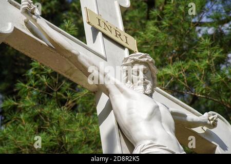 Nahaufnahme von Jesus am Kreuz, ausgestreckte Arme, in alter Friedhofstatue. Stockfoto