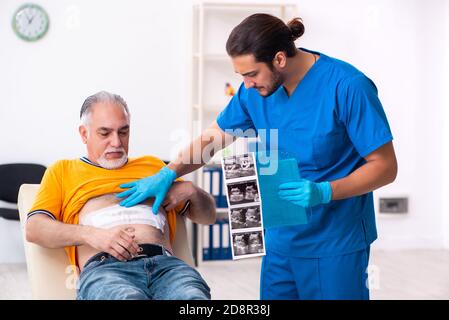 Alter Mann, der männlichen Arzt besucht Stockfoto