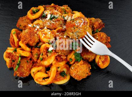 Fleischbällchen von Rind und Schwein Al Forno mit Trulli-Pasta Tomatensauce Mahlzeit auf einem Schieferstein Hintergrund Stockfoto