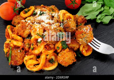 Fleischbällchen von Rind und Schwein Al Forno mit Trulli-Pasta Tomatensauce Mahlzeit auf einem Schieferstein Hintergrund Stockfoto