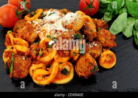 Fleischbällchen von Rind und Schwein Al Forno mit Trulli-Pasta Tomatensauce Mahlzeit auf einem Schieferstein Hintergrund Stockfoto