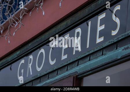 Ein vintage Emaille Werbeschild außerhalb eines Lebensmitteleinzelhandels Geschäfte auf der Hauptstraße sagen Lebensmittel. Stockfoto