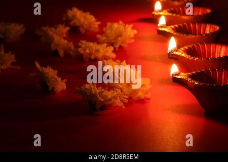 diya Lampen beleuchtet während diwali Feier mit Blumen Stockfoto