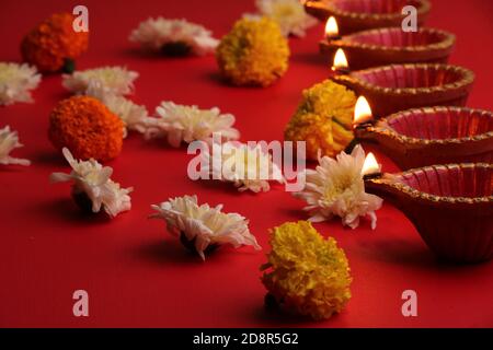 diya Lampen beleuchtet während diwali Feier mit Blumen Stockfoto