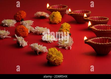 diya Lampen beleuchtet während diwali Feier mit Blumen Stockfoto