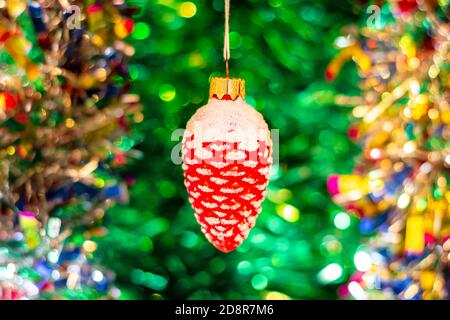 Vintage Glas Sowjetisches Neujahrsspielzeug (goldener Fisch) vor dem Hintergrund eines Weihnachtsbaums und farbenfroher heller Lametta. Stockfoto