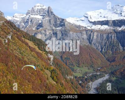 LUFT-LUFT-ANSICHT. Gleitschirmfliegen über dem Giffre Valley in Richtung Tenneverge Peak. Sixt-Fer-à-Cheval, Haute-Savoie, Auvergne-Rhône-Alpes, Frankreich. Stockfoto