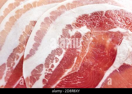 Nahaufnahme von rohem, runder, in Scheiben geschnittenem Speck. Fleisch Hintergrund. Stockfoto