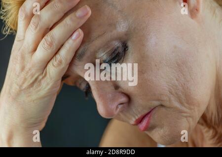 Porträt einer weißen Frau mittleren Alters, die vor Schmerz und Verzweiflung weint, mit Make-up, das ihr ins Gesicht läuft Stockfoto