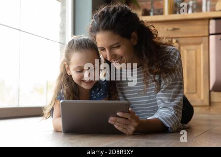 Glückliche Mutter und kleine Tochter mit Tablet zusammen Stockfoto