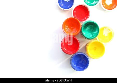 Offene Gouache-Gläser auf weißem Hintergrund, flache Lay-Komposition, Draufsicht.Copy space.Flat Lay-Komposition mit Gouache-Farben und Pinsel.Werbung Stockfoto