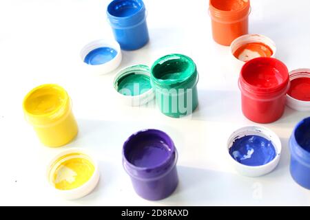 Offene Gouache-Gläser auf weißem Hintergrund, flache Lay-Komposition, Draufsicht.Copy space.Flat Lay-Komposition mit Gouache-Farben und Pinsel.Werbung Stockfoto