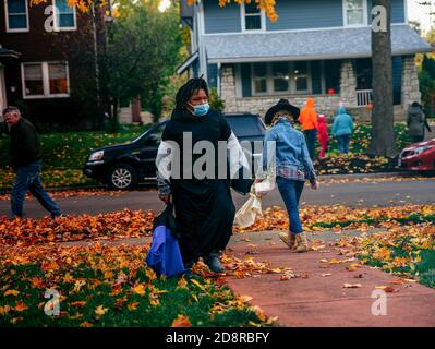 Mit Schutzmasken gehen Trick-or-treaters Tür-zu-Tür während Oakwoods erstem 'COVID-19 Halloween'. Normalerweise erwartet Volusia Hunderte von Trick-or-Treatern, aber während des ersten "COVID-19 Halloween" in Amerika spielten Eltern es sicher, Familien trugen Masken mit ihren Kostümen und Eltern sorgten dafür, dass ihre Kinder ihre Masken nicht auszogen oder zu nahe an diejenigen kamen, die sie nicht kannten, aufgrund von Coronavirus-Ängsten. Viele entschieden sich ganz aus den Festlichkeiten, aber diejenigen, die aus wagten, wurden mit Eimern voller Süßigkeiten und gutherzige, aber distanzierte Wellen von Nachbarn erfüllt. Stockfoto