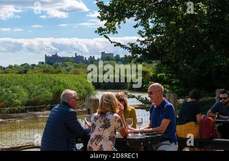 Kunden im öffentlichen Haus Black Rabbit sitzen im Sommer bei einem Drink am Tidal River Arun, Arundel, West Sussex, England, UK Stockfoto