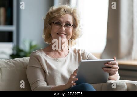 Porträt von schönen lächelnden älteren Frau mit digitalen Tablet. Stockfoto