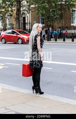Weibliche Ministerialberin hält britische Regierung roten Kasten, Ministerialkasten (Versand-Kasten) außerhalb Kabinett Büro, Whitehall, Westminster, London, Großbritannien Stockfoto