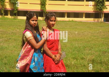 Nahaufnahme von zwei Schwestern tragen traditionelle Saree und Schmuck wie Nasenringe Ohrringe maang tika Armreifen während Durga Puja, selektive Fokussierung Stockfoto