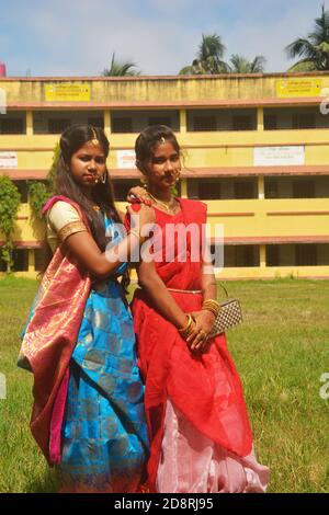 Nahaufnahme von zwei Schwestern tragen traditionelle Saree und Schmuck wie Nasenringe Ohrringe maang tika Armreifen während Durga Puja, selektive Fokussierung Stockfoto