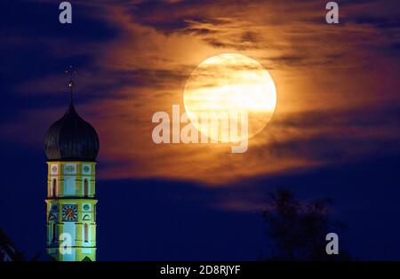 Vollmond, der aufgehende Mond über dem Horizont hinter der Barockkirche St. Martin, der katholischen Pfarrkirche Marktoberdorf i. Stockfoto