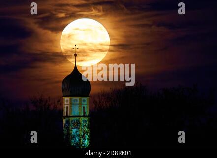 Vollmond, der aufgehende Mond über dem Horizont hinter der Barockkirche St. Martin, der katholischen Pfarrkirche Marktoberdorf i. Stockfoto