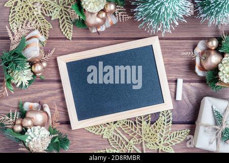 Mockup Kreidetafel mit leeren Bildschirm, Neujahr Geschenk-Box mit Xmas Kiefer Modell, weihnachtsschmuck auf Holzhintergrund, Draufsicht, Kopierraum p Stockfoto