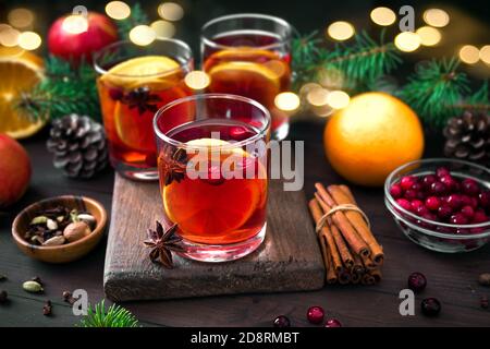 Weihnachtlicher Glühwein mit Gewürzen und Orangen auf rustikalem Holztisch. Traditionelles Heißgetränk für Weihnachten und Winterferien. Stockfoto