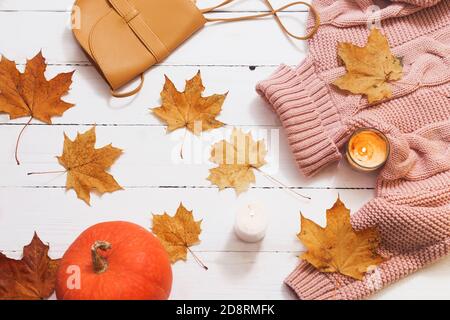 Herbststillleben, gelbe Blätter, Kürbis, Kerzen, Strickpullover auf weißem Hintergrund, Draufsicht Stockfoto