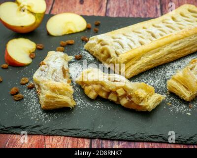 Köstliche Apfelkuchen oder Apfelstrudel auf schwarzem Schiefer serviert Stockfoto