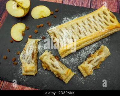 Köstliche Apfelkuchen oder Apfelstrudel auf schwarzem Schiefer serviert Stockfoto