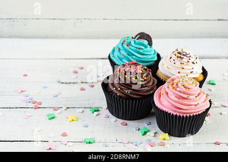 Leckere bunte Cupcakes isoliert auf Holz Hintergrund. Köstlicher Cupcake Stockfoto