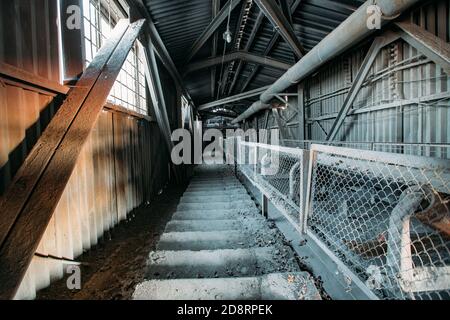 Verlassene Zement und Beton Fabrik. Alte rostige Förderanlage im Korridor Stockfoto