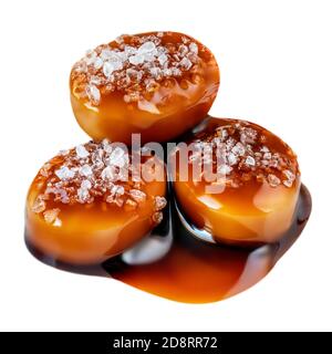 Salzige Karamell Bonbons mit Karamell-Sauce isoliert auf einem weißen Hintergrund close up. Stockfoto