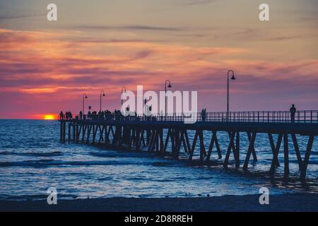 Glenelg Jetty mit Menschen bei Sonnenuntergang, South Australia Stockfoto